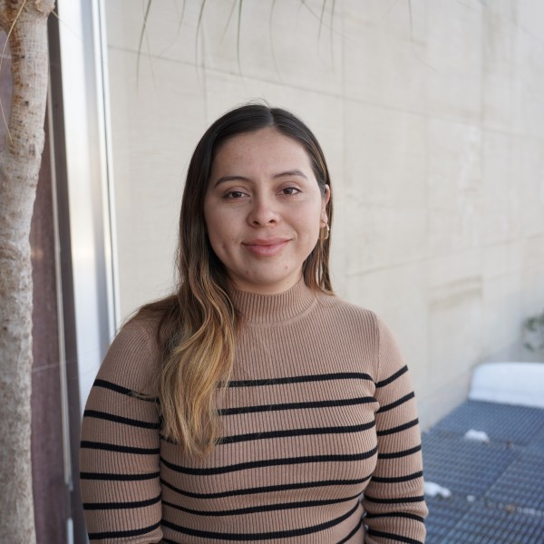 A woman smiles, posing for a photo.