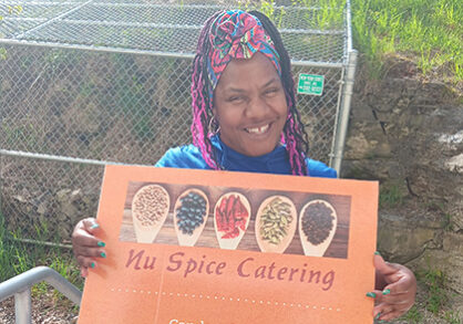 Candice holding a Nu Spice sign
